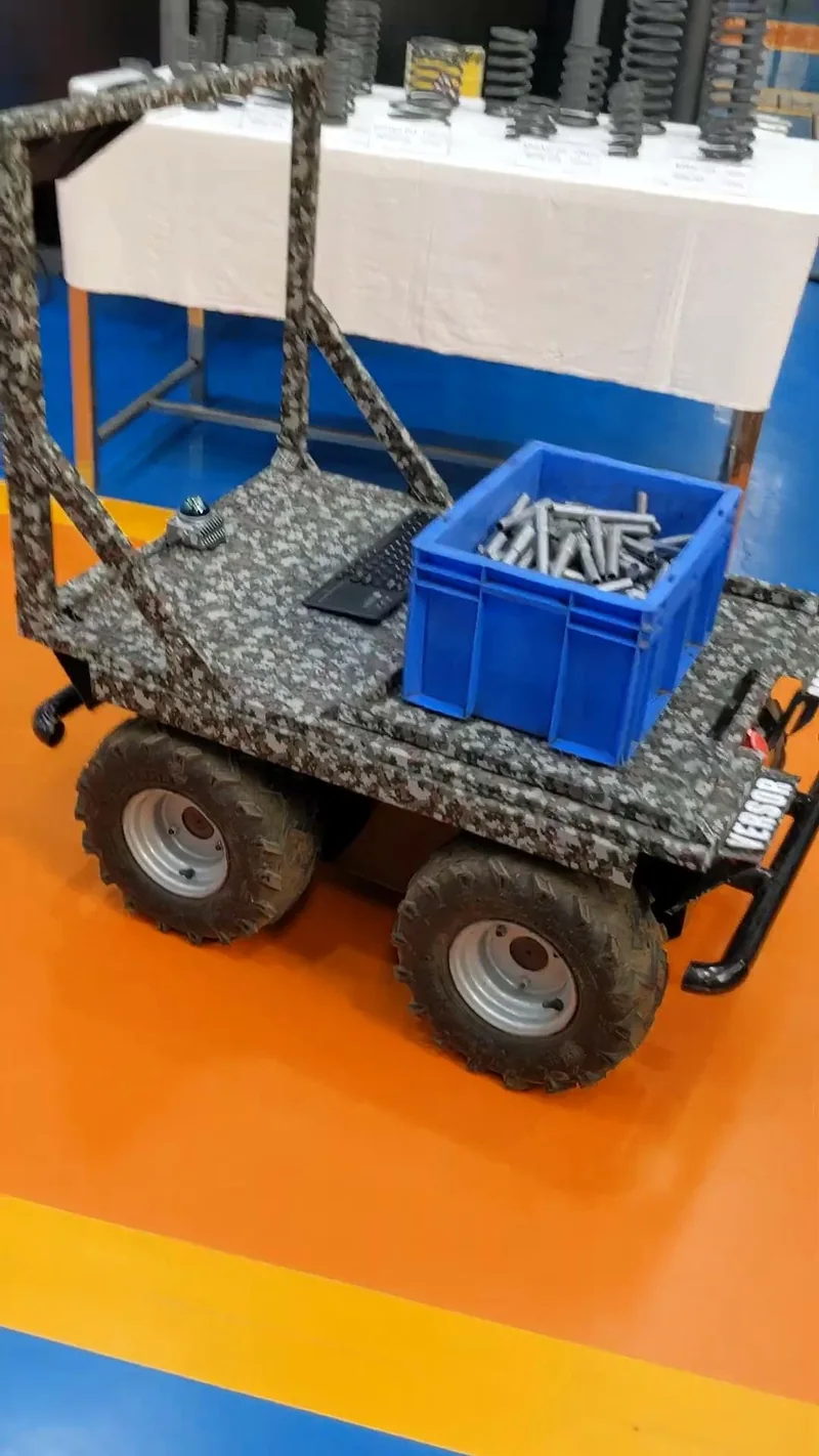 The Versor robot carrying a blue crate full of metal parts